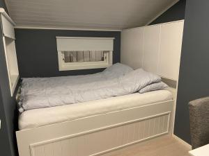 ein kleines Schlafzimmer mit einem Bett und einem Fenster in der Unterkunft Privat hjem i Grimstad - Nær Arendal og Dyreparken in Grimstad