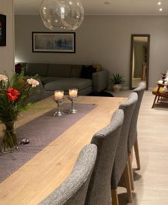 ein Wohnzimmer mit einem Tisch mit Stühlen und einem Sofa in der Unterkunft Privat hjem i Grimstad - Nær Arendal og Dyreparken in Grimstad