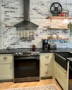 a kitchen with a stove and a stone wall at New Construction Cottage in Downtown Savannah Arts District in Savannah