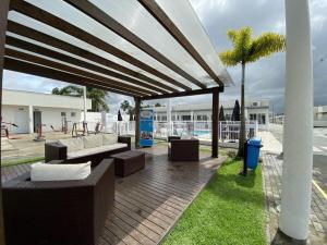 ピサーハスにあるResidencial Angelus Condomínio Clube na Praia de Piçarrasのパティオ(ソファ、椅子付)、プールが備わります。
