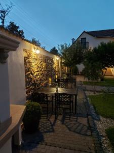 a patio with a table and chairs and a stone wall at Conacul Poetilor in Gura Rîului