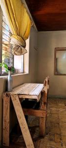 uma mesa de madeira num quarto com uma janela em Casa I`X em Quetzaltenango