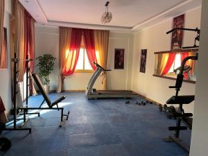a gym with several tread machines in a room at فيلا للايجار اليومى اوالشهرى فى الريف الاوربي- طريق مصر اسكندرية الصحراوى- قريبة من مطار سفنكس -بجوار هايبر وان الصحراوى in Qaryat ash Shamālī