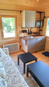 a living room with a couch and a kitchen at Happy Cottage 