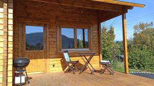 eine Hütte mit einem Tisch und Stühlen auf einer Terrasse in der Unterkunft Happy Cottage 