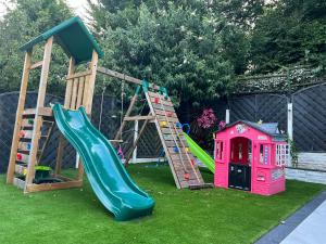 un parque infantil con tobogán y una casa de juegos en Large NEW Detached House Woolton, Families, FREE Parking, Massage, BBQ, Play room & MORE, en Woolton