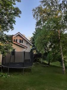 una casa con una rampa en un patio con árboles en Yö Vaahteramäellä 