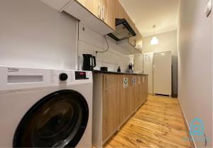 a kitchen with a washing machine in a room at Ocular Room in Gdańsk