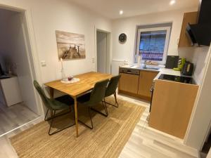a kitchen with a wooden table and chairs in a room at Schön, praktisch & zentrale Lage in Bergrheinfeld