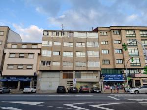 a large building with cars parked in front of it at MEDA Padrón in Padrón