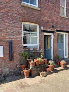 a group of potted plants sitting outside of a brick building at Riverside Victorian home in Neepsend