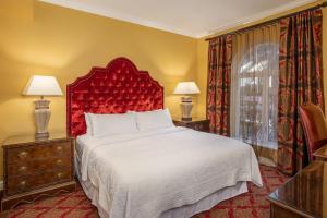 a bedroom with a large bed with a red headboard at Casa Monica Resort & Spa, Autograph Collection in Saint Augustine
