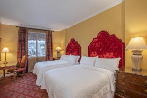 a hotel room with two beds with red headboards at Casa Monica Resort & Spa, Autograph Collection in St. Augustine