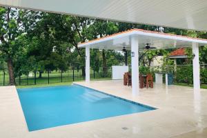 um pavilhão sobre uma piscina com uma mesa e cadeiras em Sublime Villa in the Heart of Playa Coronado em Playa Coronado
