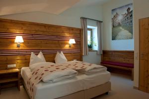 a bedroom with a large bed with a wooden headboard at Landhotel Gockelwirt in Eisenberg