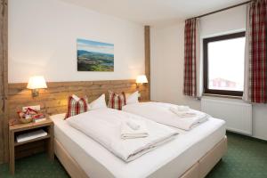 a bedroom with two beds with white sheets and a window at Landhotel Gockelwirt in Eisenberg