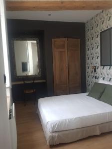 um quarto com uma cama branca e um espelho em Le Merlane - A 2 pas de la Cité & du centre ville em Carcassonne