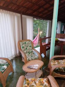 sala de estar con sillas de mimbre y mesa en Pousada Canto Feliz, en Serra do Cipo