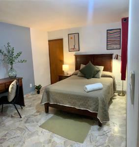 a bedroom with a bed with two pillows on it at Casa Tigris in Mexico City