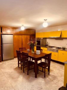 a kitchen with a table with chairs and a refrigerator at Casa Tigris in Mexico City
