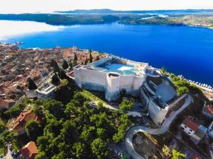 an aerial view of a house on a hill next to the water at Olive Garden House in Šibenik
