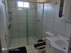 a bathroom with a shower and a toilet and a sink at Aconchegante Casa na Montanha in Urubici