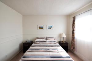a bedroom with a bed with two night stands and a window at The Comfort Stay at City of Pickering in Pickering