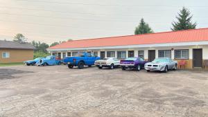 un grupo de coches aparcados delante de un edificio en Rolphton Motel and Restaurant, en Moor Lake Station
