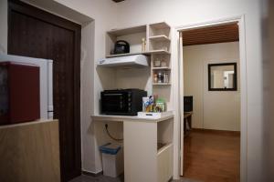 um quarto com uma cozinha com um micro-ondas e uma prateleira em Euaggelias & Cristianas House em Aristi