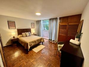 a bedroom with a bed and a large window at Casa Tigris in Mexico City
