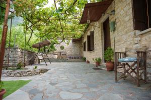 a stone patio in front of a stone house at Euaggelias & Cristianas House in Aristi