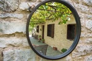 um reflexo de espelho de um pátio numa parede de tijolos em Euaggelias & Cristianas House em Aristi