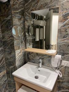 a bathroom with a sink and a mirror at SOL INVICTUS Boutique Hotel Durres Albania in Durrës