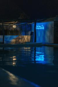 a swimming pool at night with blue lights at Hotel Bungalows Marbella Costa Esmeralda in Monte Gordo
