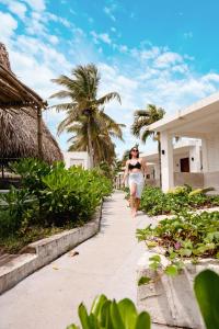 a woman walking down a sidewalk in front of a building at Hotel Bungalows Marbella Costa Esmeralda in Monte Gordo