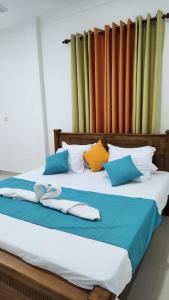 un letto con cuscini colorati sopra di Calm Guest a Trincomalee