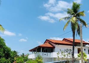a house with palm trees in the foreground at Calm Guest in Trincomalee