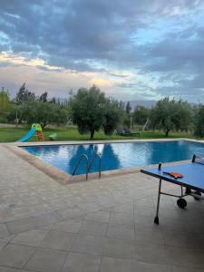 a ping pong table next to a swimming pool at Villa de l'ATLAS in Marrakesh