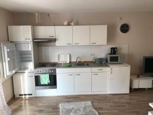 a kitchen with white cabinets and a sink and a microwave at Lindenberger Ferientraum in Lindenberg im Allgäu