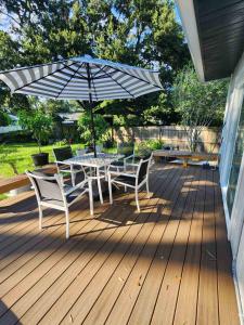 a table and chairs with an umbrella on a deck at Cozy Bedroom with Private Ensuite Bathroom - Room # 2 in SAHRED house NO PET in Orlando