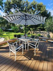 a table and chairs under an umbrella on a deck at Cozy Bedroom with Private Ensuite Bathroom - Room # 2 in SAHRED house NO PET in Orlando