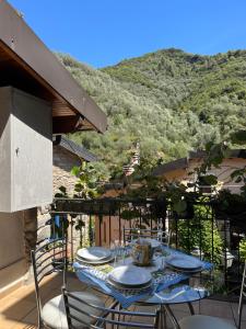 a table on a balcony with a view of a mountain at Casa Victoria - Full equipped stone house in Rocchetta Nervina