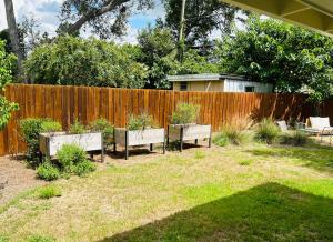 un patio trasero con tres bancos con plantas. en GardenHouse @AudubonPark Sleeps 8 en Orlando