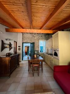 a kitchen with a wooden ceiling and a table and chairs at Casa Victoria - Full equipped stone house in Rocchetta Nervina