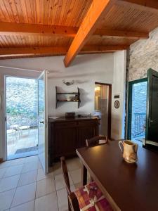 a kitchen with a table and chairs and a sliding glass door at Casa Victoria - Full equipped stone house in Rocchetta Nervina