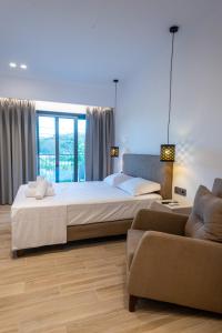 ein Schlafzimmer mit einem großen Bett und einem Sofa in der Unterkunft PARGA 4 SEASONS VILLAS in Parga