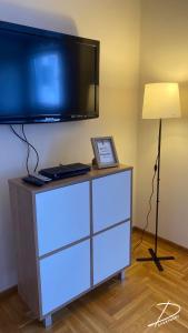 a flat screen tv sitting on top of a dresser at D Apartment Free private Parking in Novi Sad