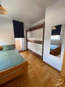 a bedroom with a bed and a mirror at D Apartment Free private Parking in Novi Sad
