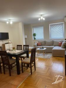 a living room with a couch and a table and chairs at D Apartment Free private Parking in Novi Sad