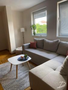 a living room with a couch and a table at D Apartment Free private Parking in Novi Sad